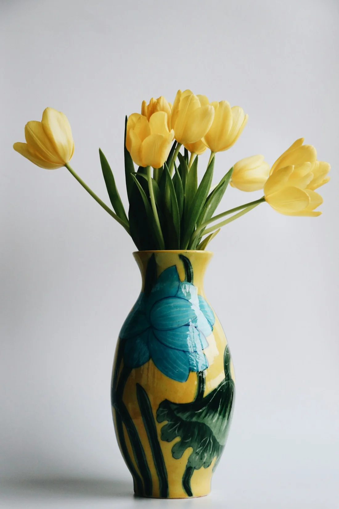 Yellow tulips in a turquoise vase